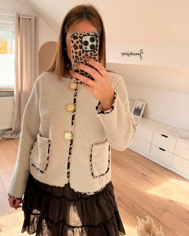 Jacke mit Leopardenbesatz und goldenen Broschen: